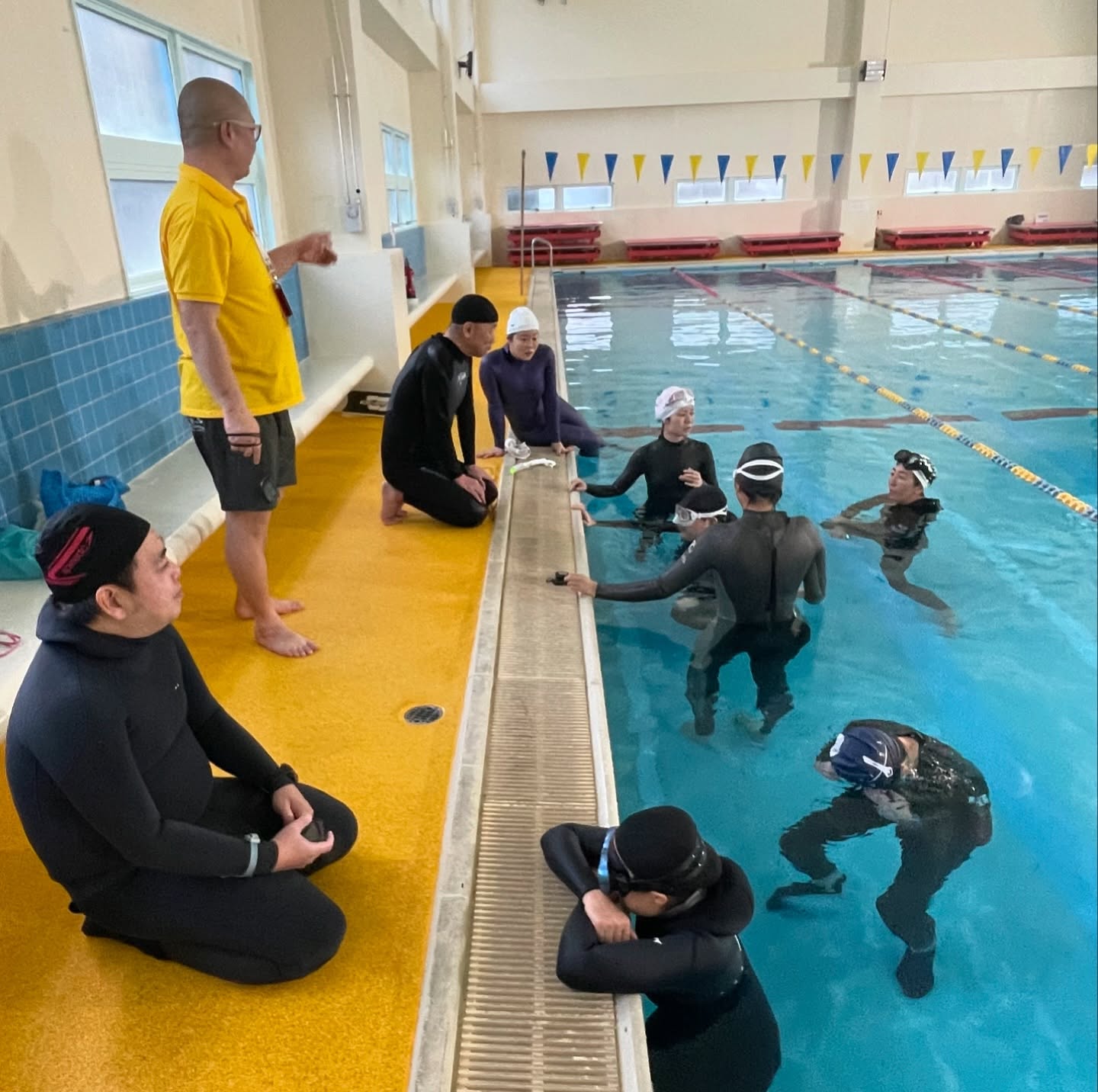 9人、泳いでいる人、プールの画像のようです